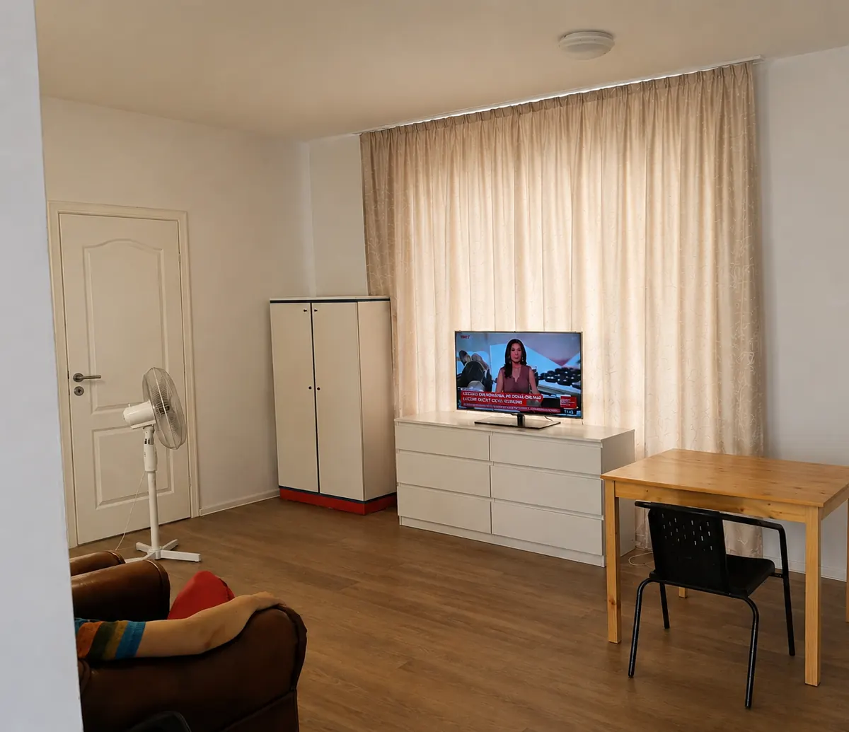 Living cu televizor, dulap și fotoliu